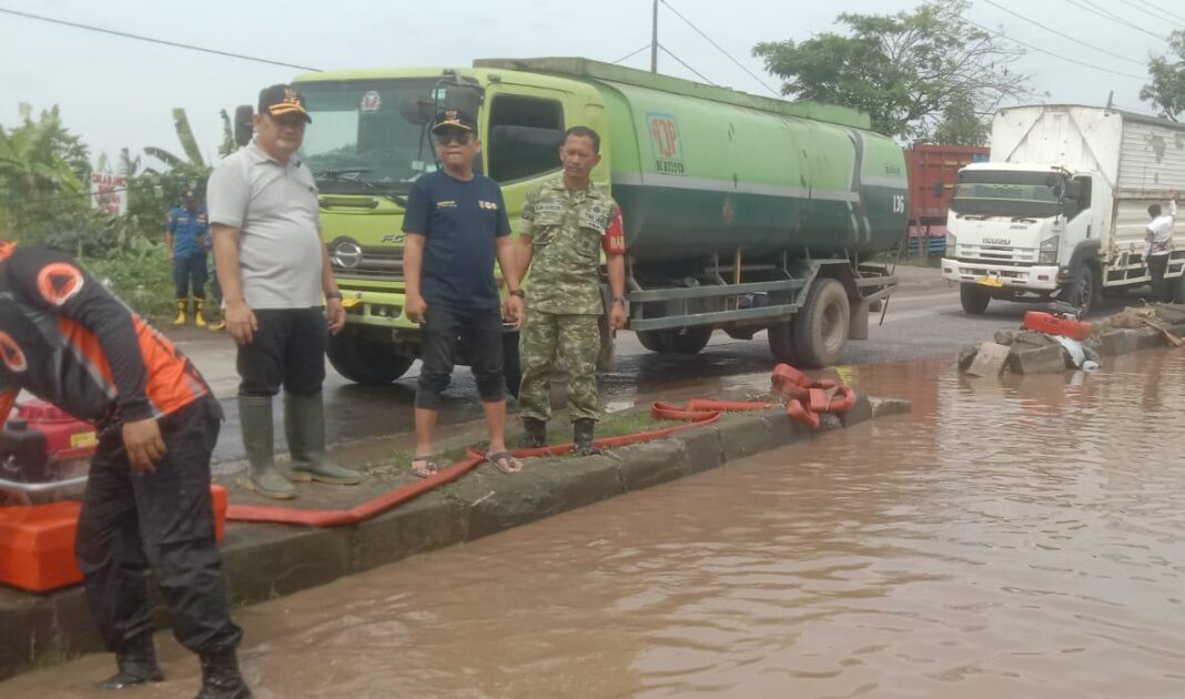 Hujan Lebat Guyur Bandar Lampung Picu Genangan Air di Badan Jalan, Babinsa Way Gubak, Sertu Aan Asrori Sigap Turun ke Lokasi Genangan