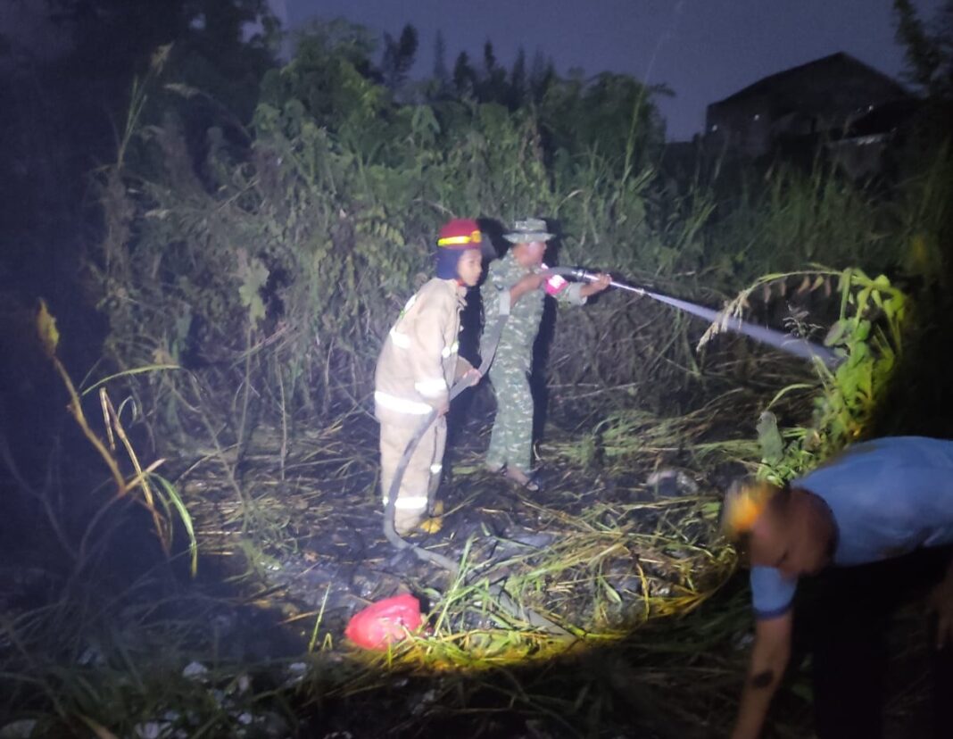 Babinsa dan Damkar Bersinergi Padamkan Kebakaran Lahan Kosong di Keteguhan